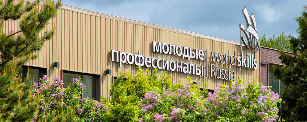 Фасад МЦК с надписью «Молодые профессионалы» и цветущей сиренью